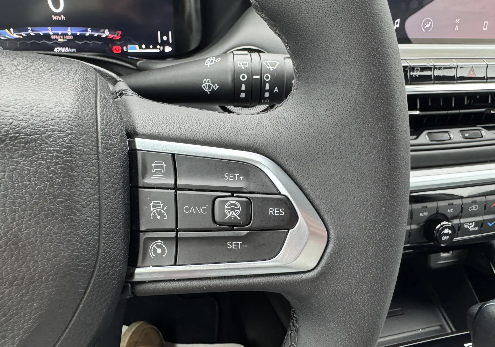 Vue rapprochée du volant côté gauche du Jeep Compass gris 2023, avec commandes de régulateur de vitesse et aides à la conduite.