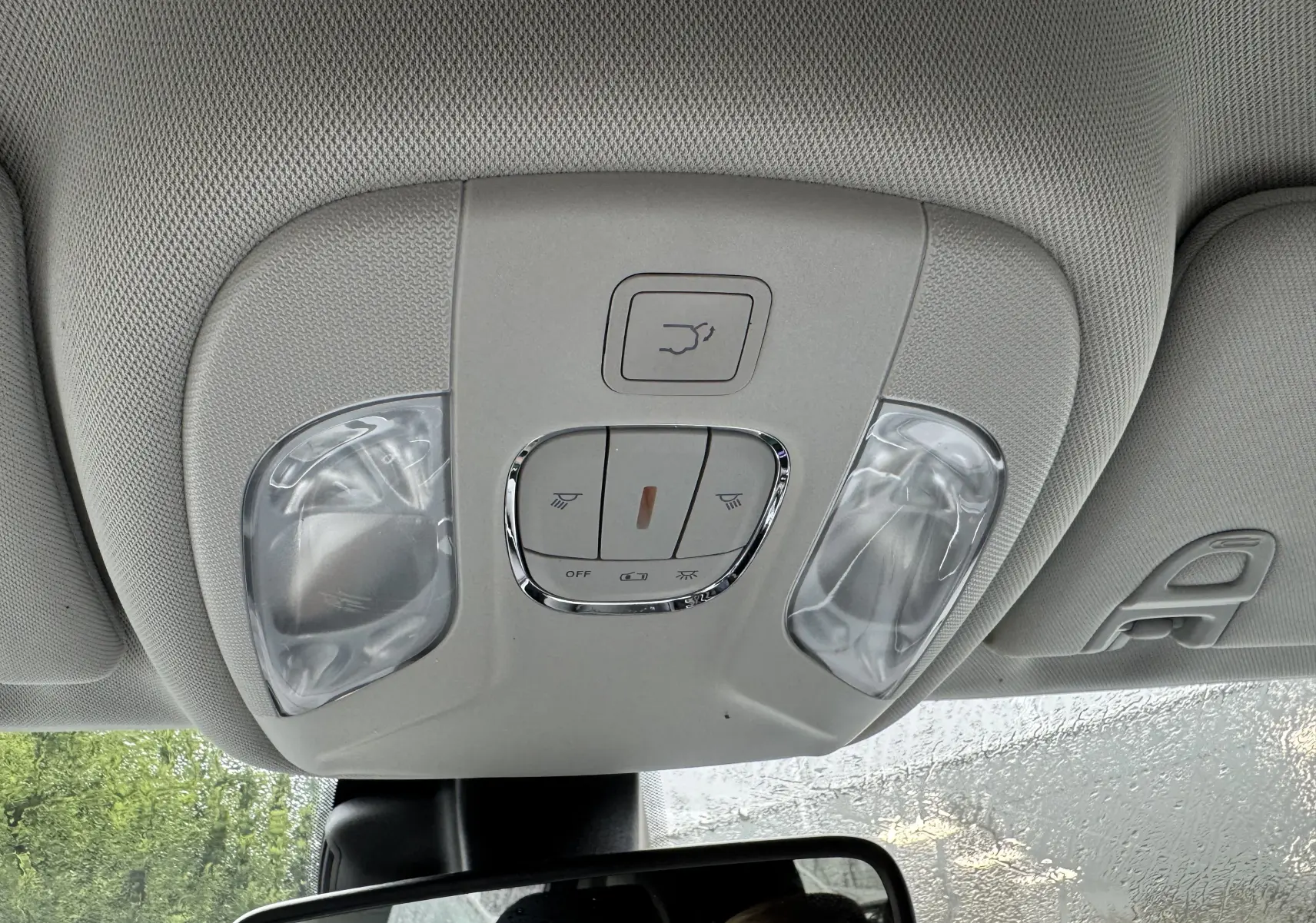 Plafonnier gris clair avec commandes d'éclairage et ouverture de coffre, au-dessus du rétroviseur intérieur d'un Jeep Compass 2023.