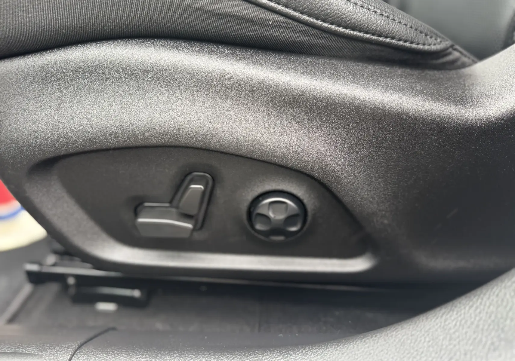 Gros plan sur les commandes de réglage électrique du siège avant en cuir noir du Jeep Compass gris 2023.