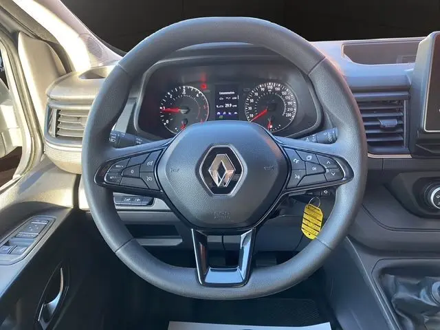 Vue rapprochée du volant noir du Renault Trafic Fourgon 2023 avec tableau de bord et commandes visibles.
