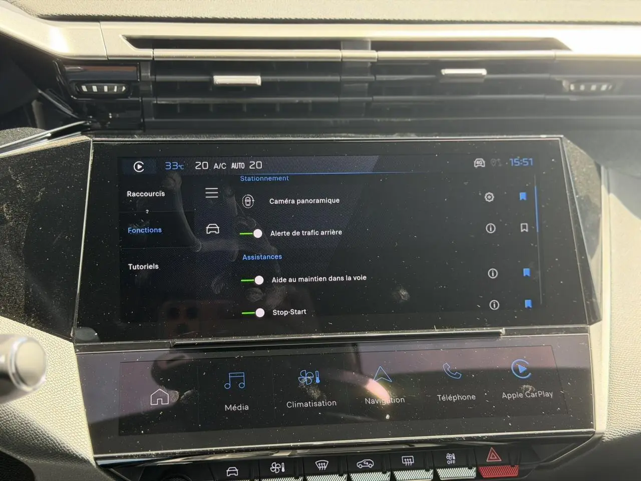 Écran tactile central de la Peugeot 308 Hybrid 145 gris Artense montrant les aides à la conduite et Apple CarPlay.