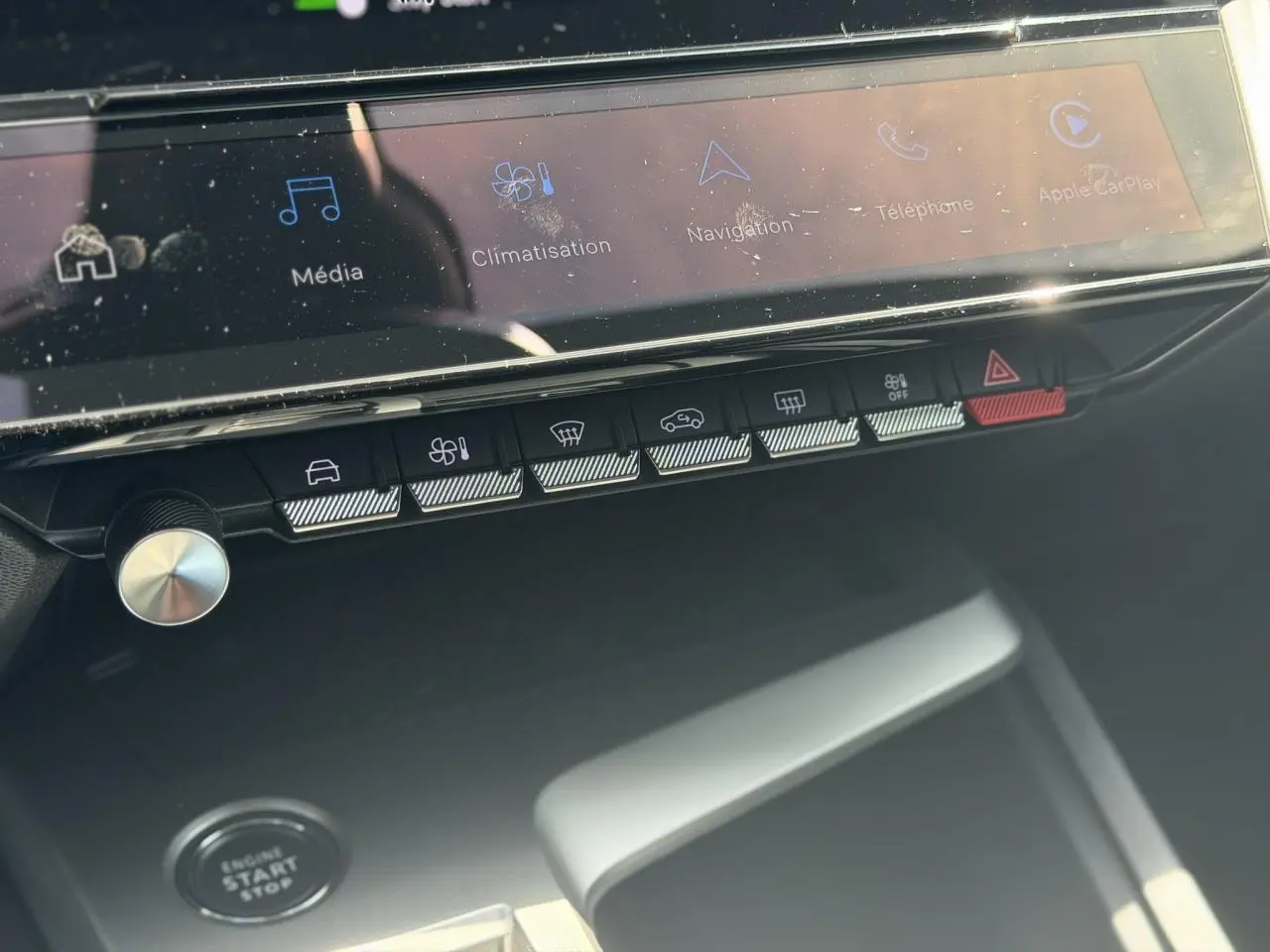Vue rapprochée de la console centrale de la Peugeot 308 Hybrid 2025, montrant l'écran tactile et les boutons de commande.