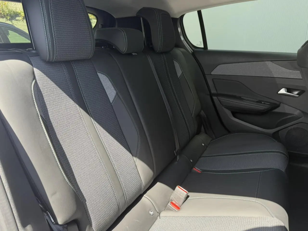 Vue latérale droite de la banquette arrière en tissu et cuir noir de la Peugeot 308 Hybrid 145 Gris Artense.