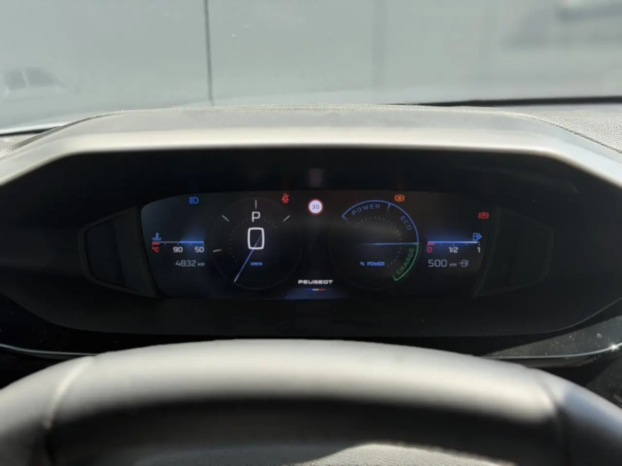 Vue rapprochée du combiné numérique Peugeot 308 Hybrid 2025 affichant la vitesse et l'autonomie, prise côté conducteur.