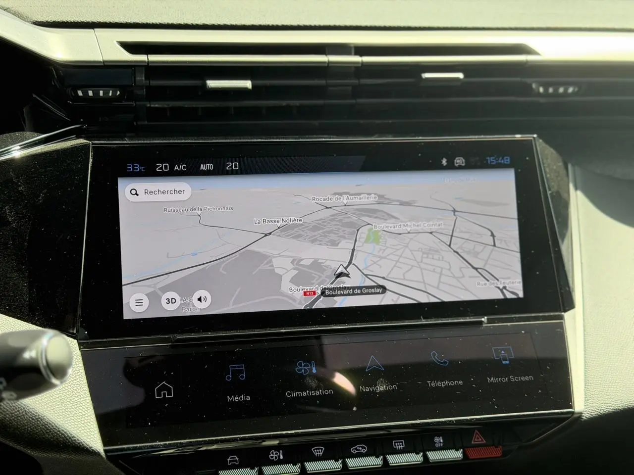 Vue rapprochée de l’écran tactile central du Peugeot 308 Hybrid 145 gris Artense, affichant la navigation connectée.