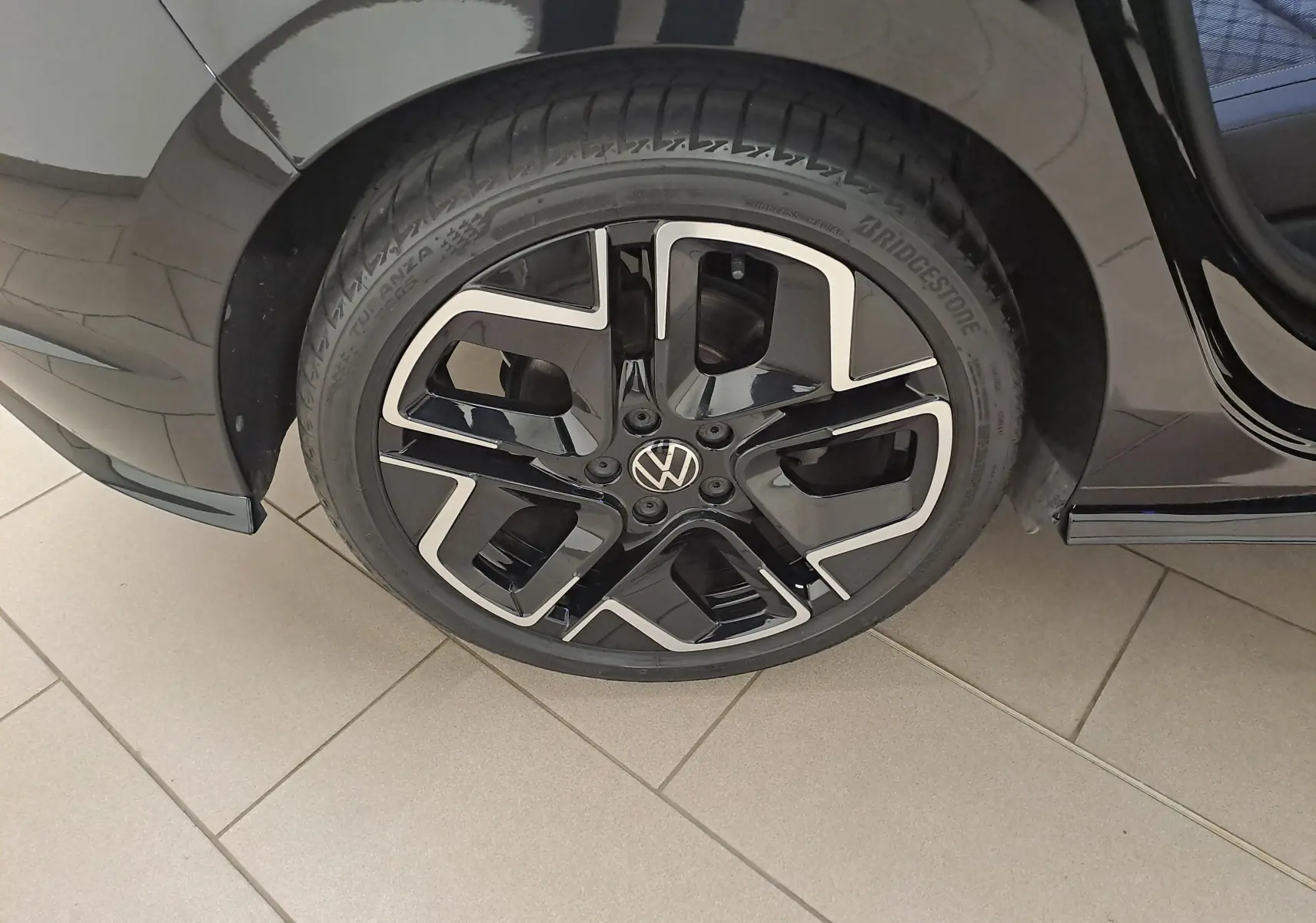 Gros plan sur la jante alliage 18'' York noire et argentée du côté arrière droit d'une Volkswagen Golf noire Grenadille.