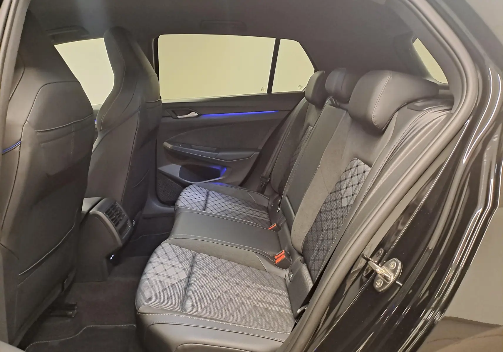 Vue côté droit de l'habitacle arrière de la Volkswagen Golf 2.0 TDI 150 DSG7 R Line noire grenadille avec sièges tissu et cuir.