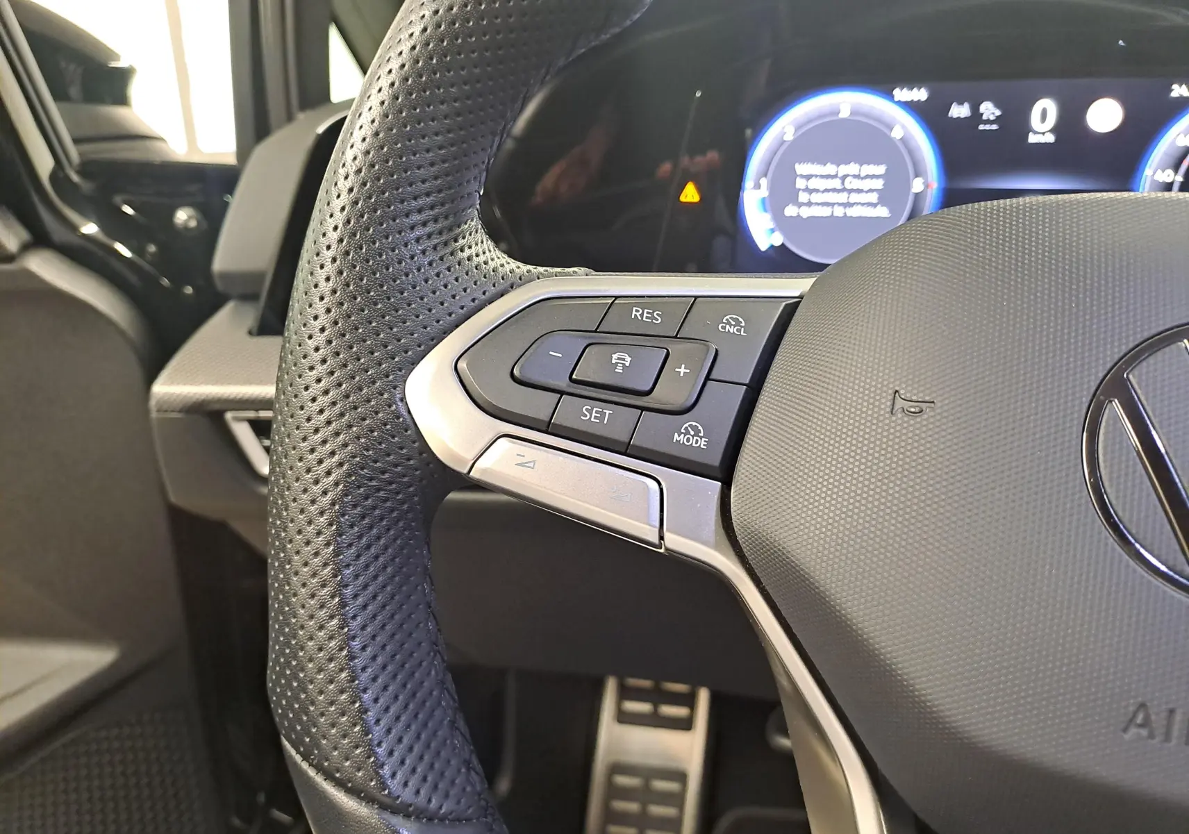 Gros plan sur le volant perforé côté gauche du Volkswagen Golf 2.0 TDI 150 DSG7 R Line 2024 noir grenadille.