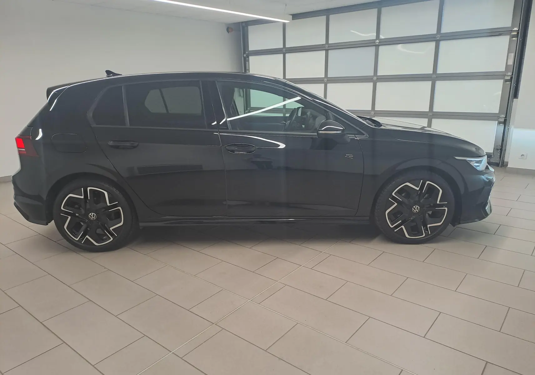 Vue de profil côté gauche d'une Volkswagen Golf 2.0 TDI 150 DSG7 R Line noire Grenadille avec jantes alliage 18'' York.