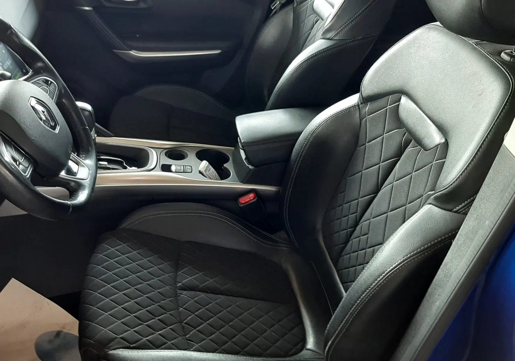 Vue intérieure côté conducteur du Renault Kadjar 1.5 DCI 115 Intens EDC 2020, sièges noirs avec surpiqûres et portière bleu iron visible.