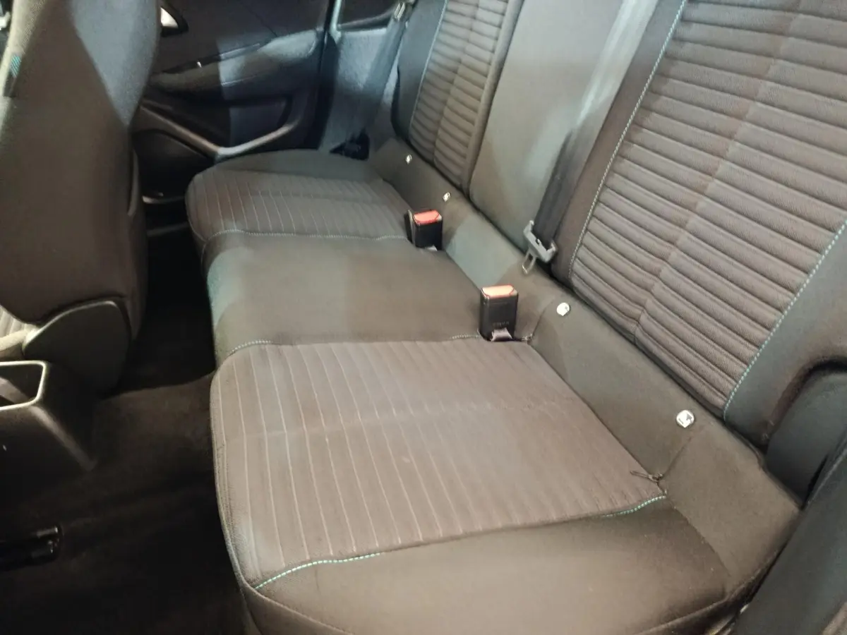 Vue intérieure de la banquette arrière noire de la Peugeot 208 PureTech 75 S&S Style 2023, avec ceintures et fixation Isofix visibles.