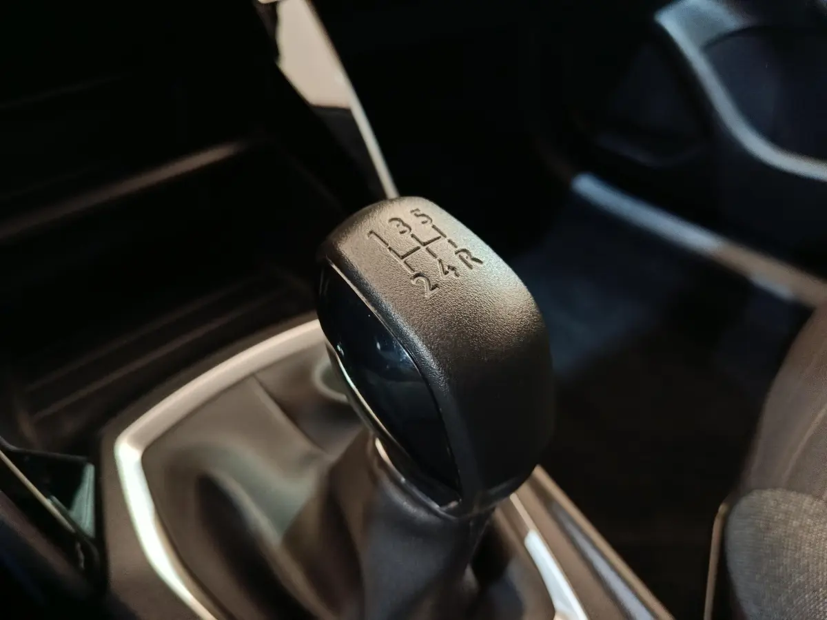 Le levier de vitesses manuel noir de la Peugeot 208 PureTech 75 S&S Style, vue rapprochée de l'intérieur.