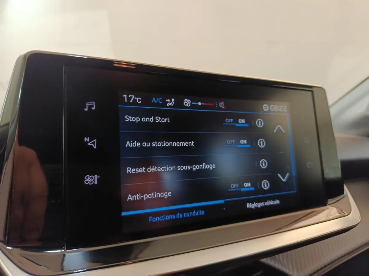 Écran tactile central de la Peugeot 208 PureTech 75 Style affichant les options d'aide à la conduite, vue intérieure.