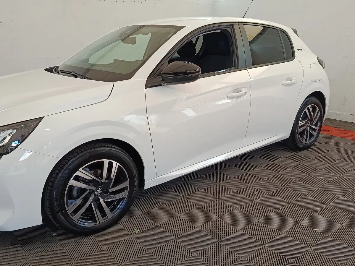 Peugeot 208 blanc vue de profil côté gauche, avec jantes alliage noires et rétroviseurs noirs brillants.