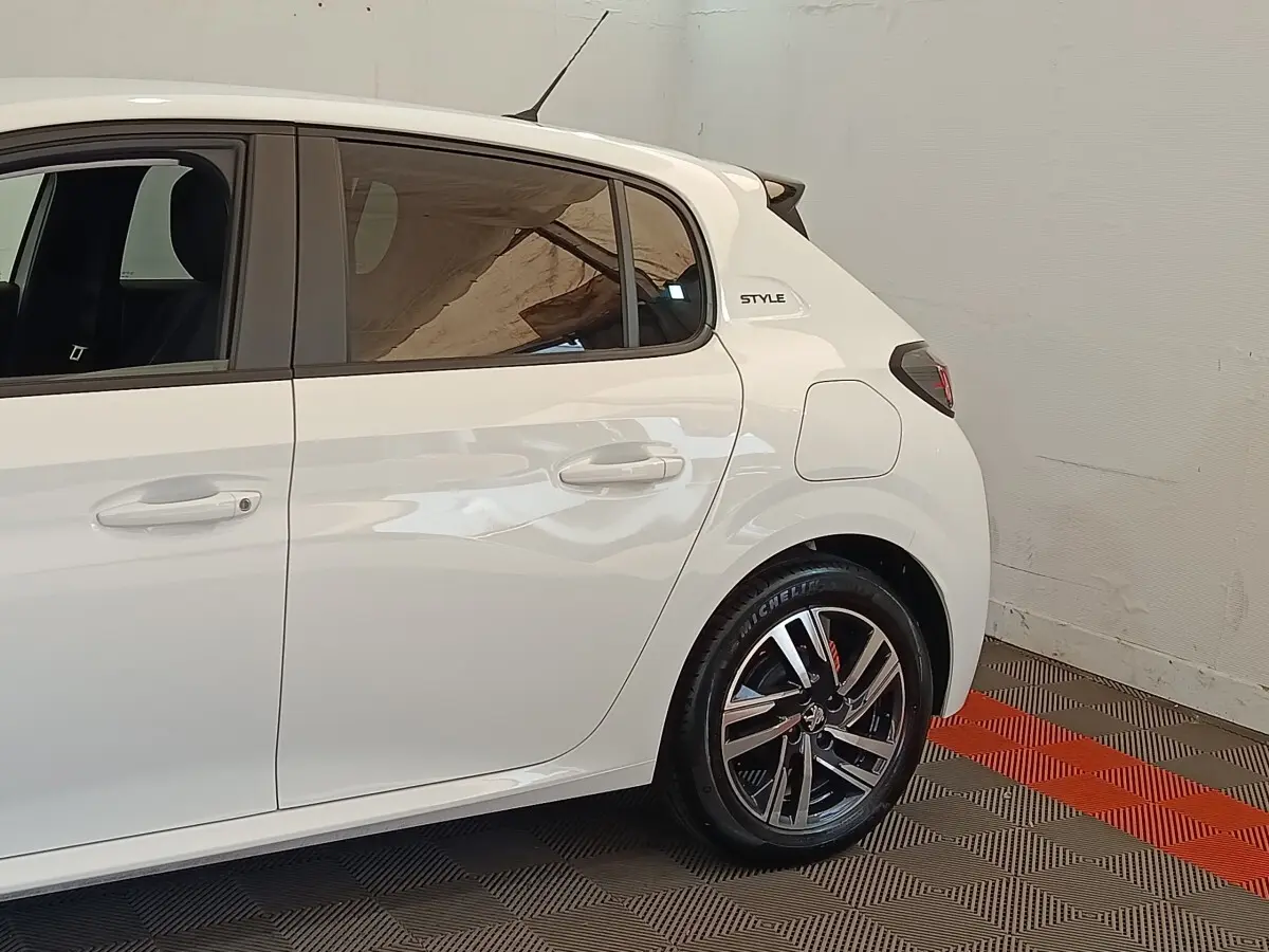 Vue latérale droite d'une Peugeot 208 PureTech 75 S&S Style blanche avec jantes alliage et badge Style arrière.