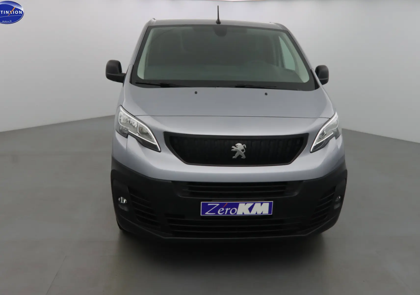 Vue frontale d'un Peugeot Expert Fourgon gris Artense métal avec calandre noire et logo lion central.