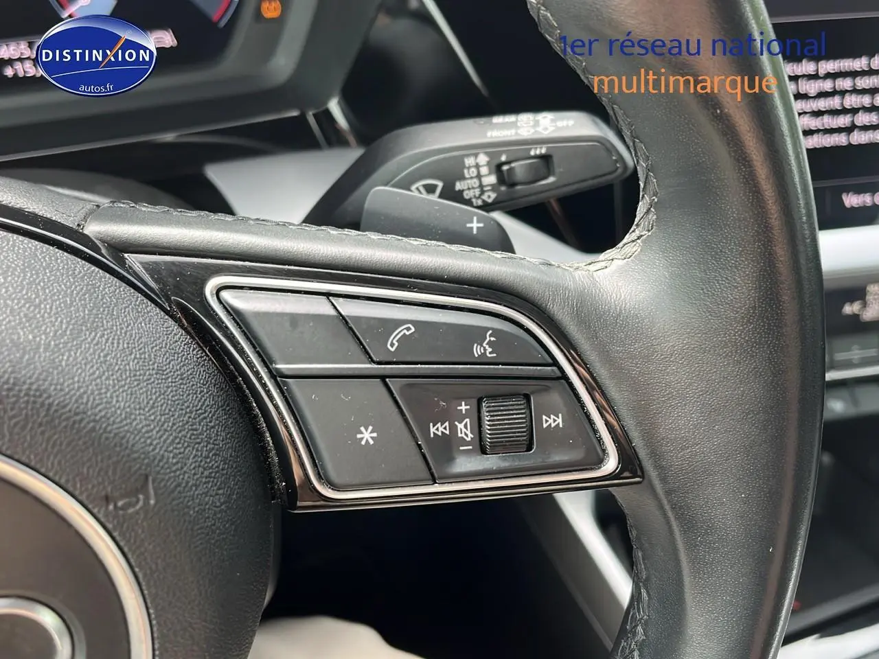 Gros plan sur les commandes du volant cuir multifonction de l'Audi A3 Sportback 2023, finition design.