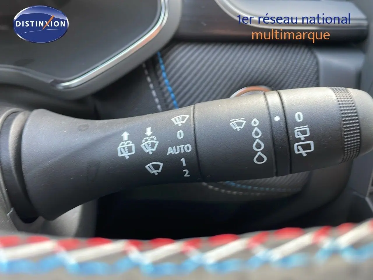 Gros plan sur la commande des essuie-glaces du Renault Captur E-Tech hybride 2025, intérieur noir avec surpiqûres bleues.