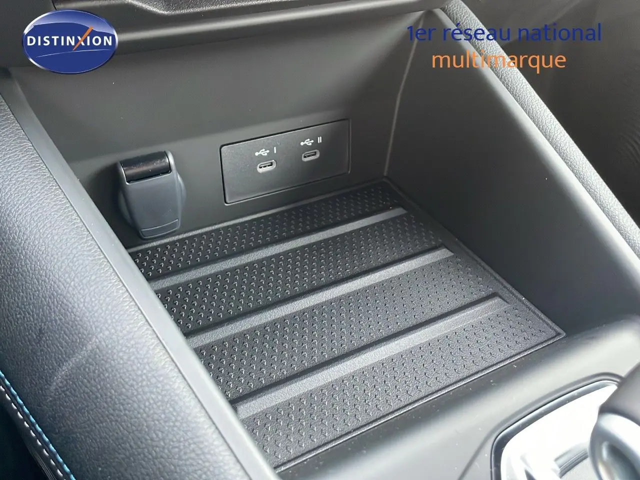 Gros plan sur la console centrale noire du Renault Captur E-Tech avec ports USB-C intégrés et surface antidérapante.