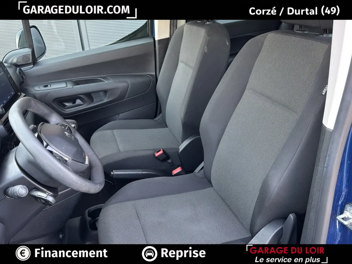 Vue intérieure côté conducteur du Peugeot Rifter bleu 2024, montrant les sièges avant en tissu gris et noir.