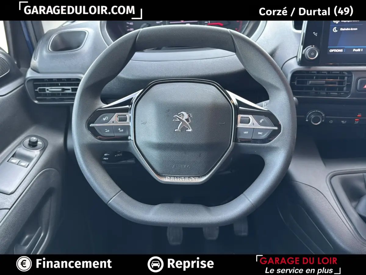 Vue rapprochée du volant Peugeot d’un Rifter 2024, avec commandes intégrées et tableau de bord noir.