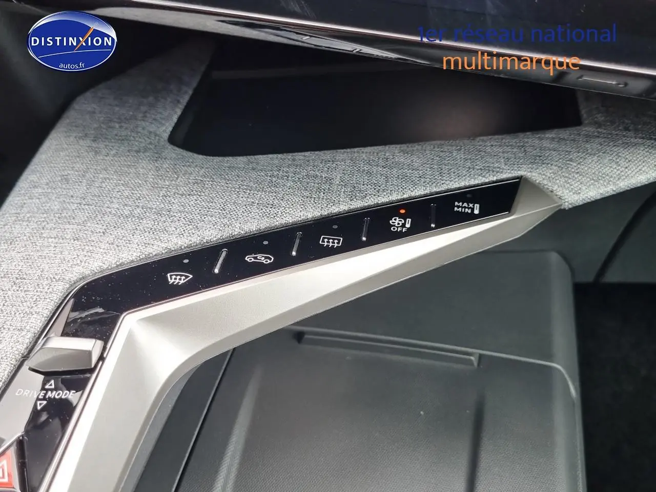 Vue rapprochée du panneau de commandes de climatisation et mode de conduite sur la console centrale grise du Peugeot 3008 blanc.