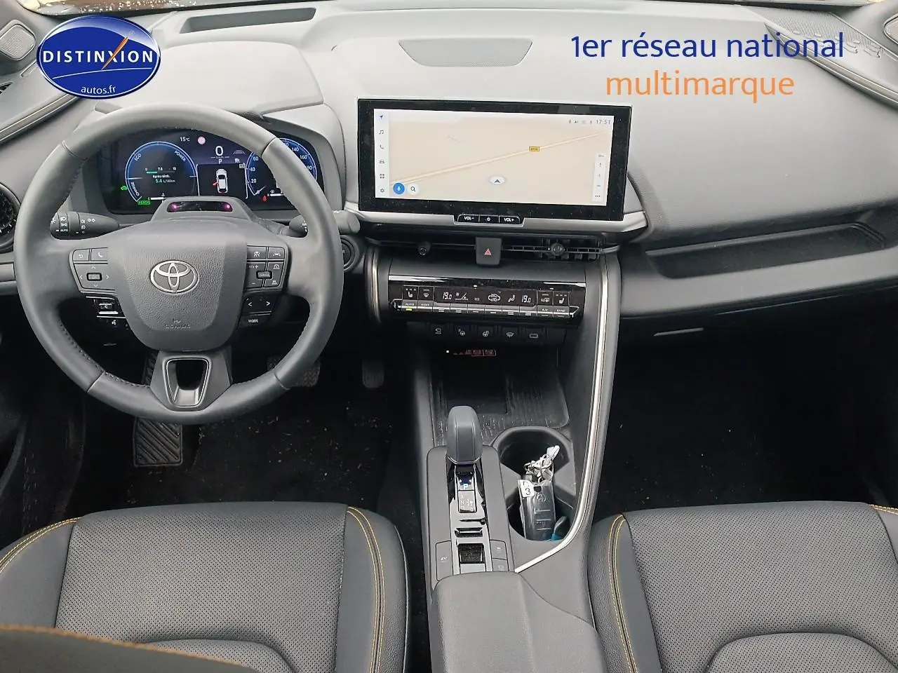 Vue intérieure frontale du Toyota C-HR hybride 2025 avec tableau de bord numérique et écran tactile central.