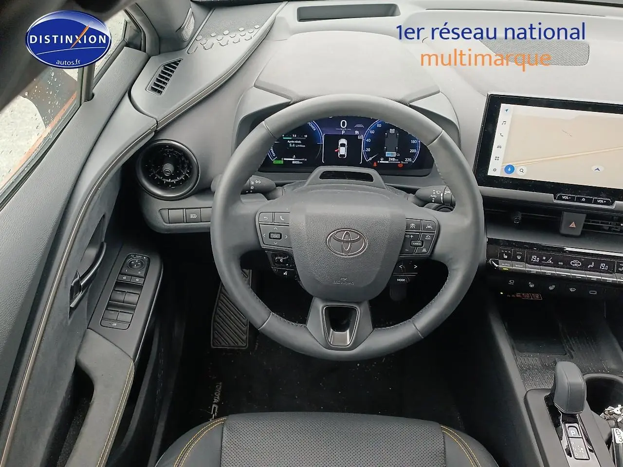 Vue intérieure centrée sur le volant et tableau de bord du Toyota C-HR hybride 2025, finition or/noir.