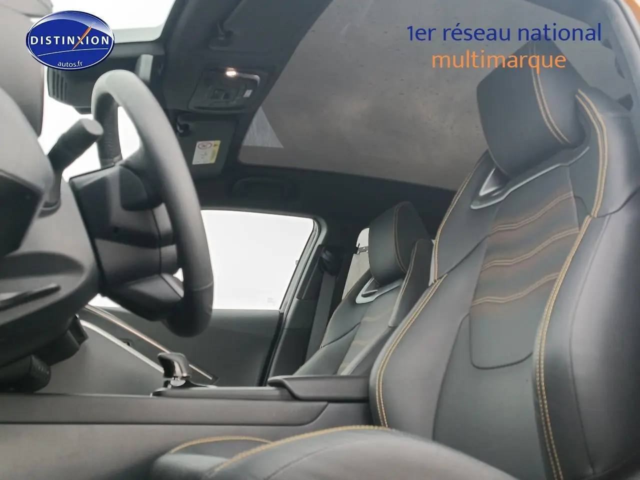 Vue intérieure avant du Toyota C-HR 2025 avec sièges sport noirs et surpiqûres or, toit panoramique en verre visible.