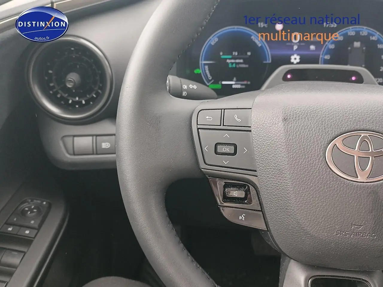 Vue rapprochée du volant multifonction noir et du tableau de bord digital du Toyota C-HR hybride 2025 or/noir.