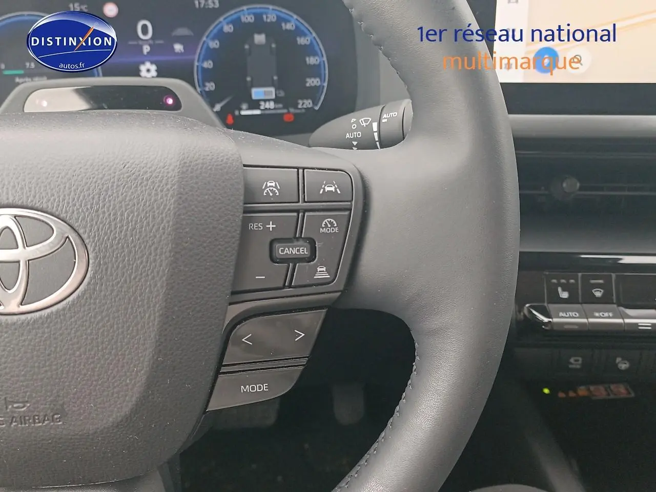 Gros plan sur le volant multifonction noir du Toyota C-HR hybride 2025 avec commandes de régulateur et affichage numérique.