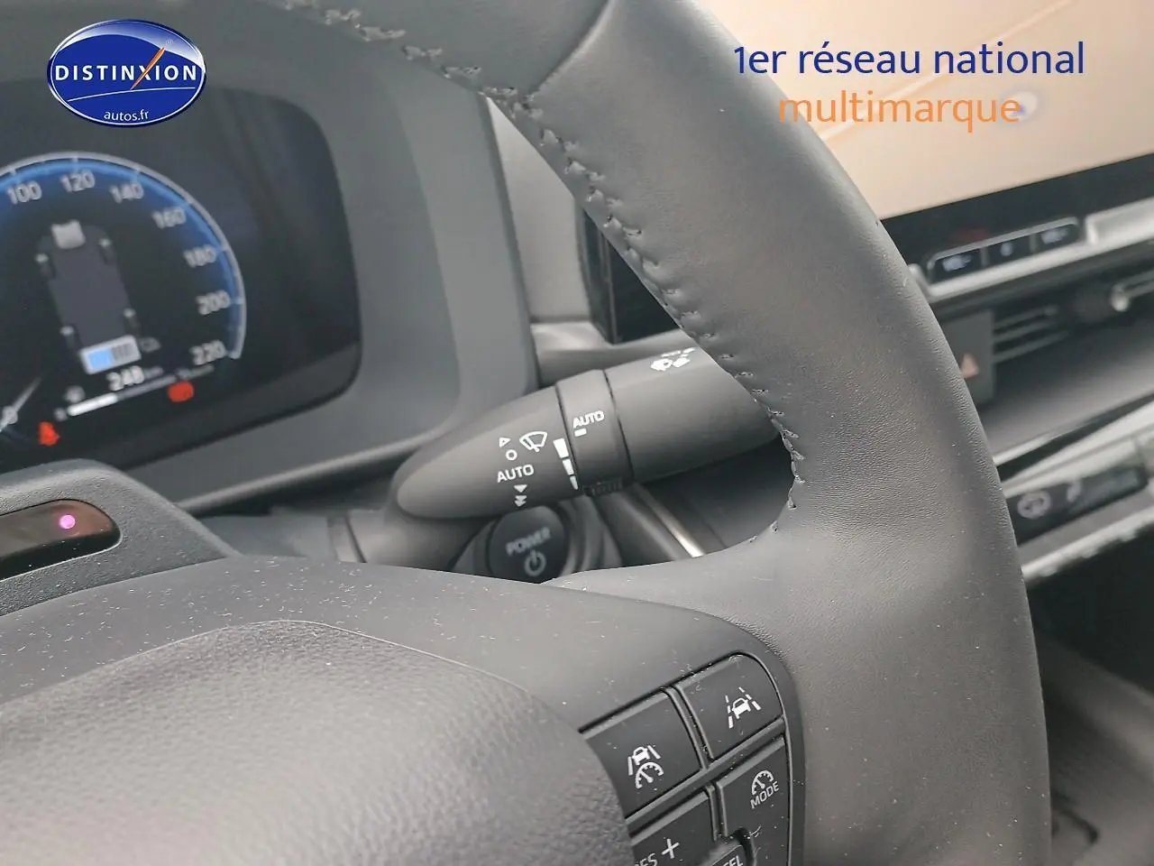 Gros plan sur le volant multifonction noir et le tableau de bord numérique du Toyota C-HR hybride 2025.