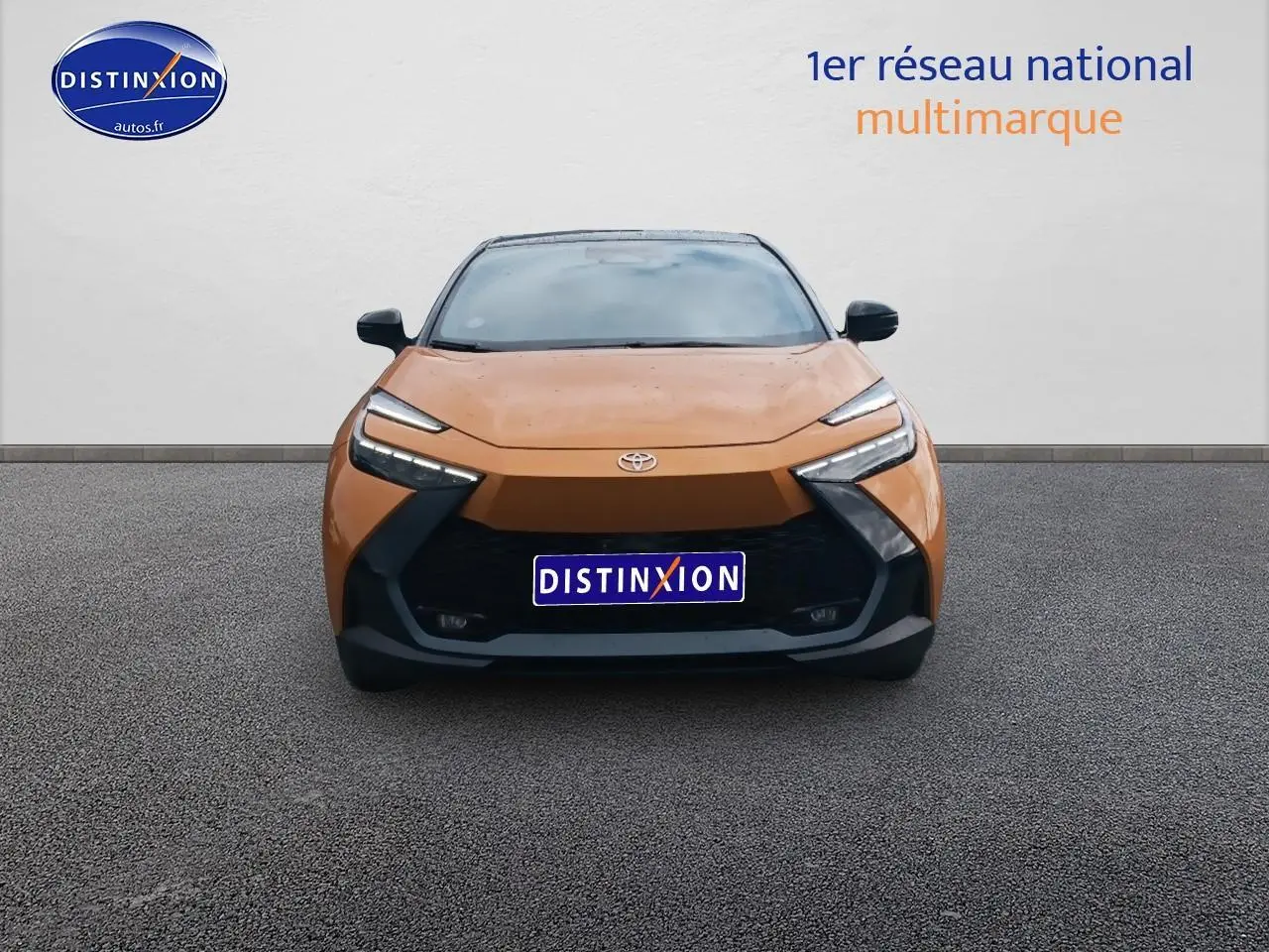 Vue frontale du Toyota C-HR 2.0 hybride 2025 en or et noir avec calandre noire et phares LED distinctifs.
