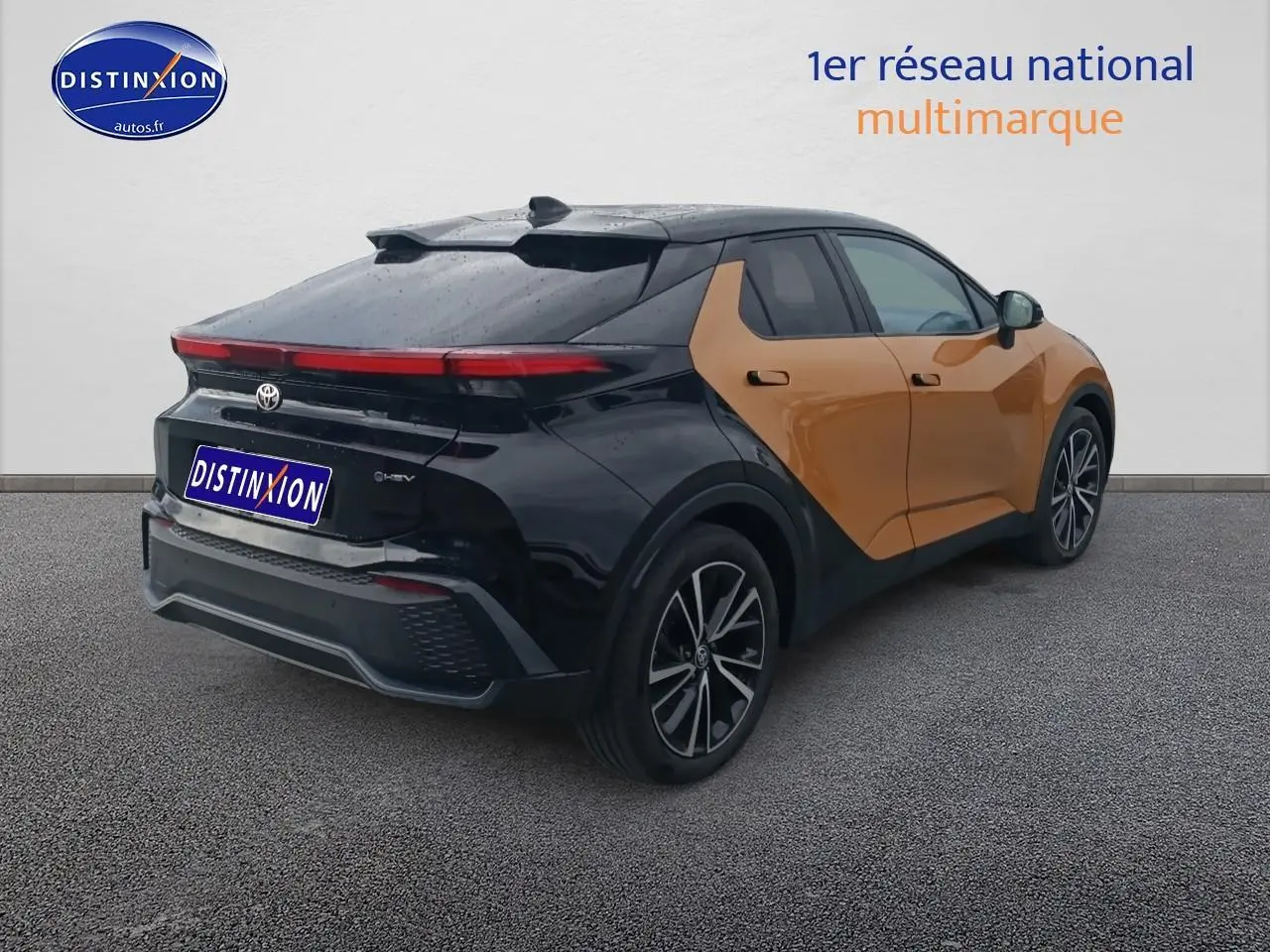 Toyota C-HR hybride 2025 or et noir, vue 3/4 arrière droit avec toit panoramique et jantes alu.