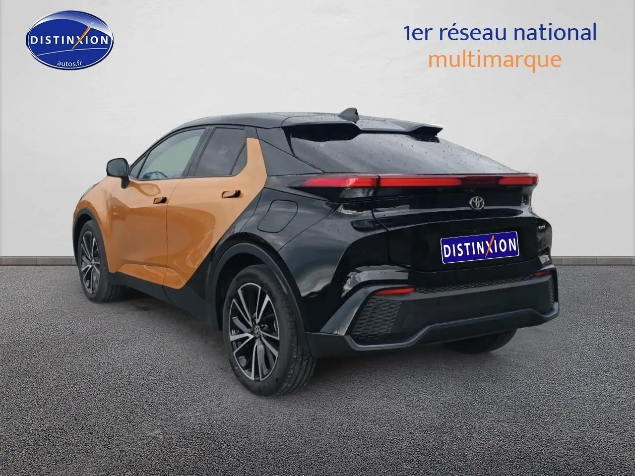 Toyota C-HR hybride 2025 or et noir, vue 3/4 arrière droit, avec toit et jantes noires distinctives.