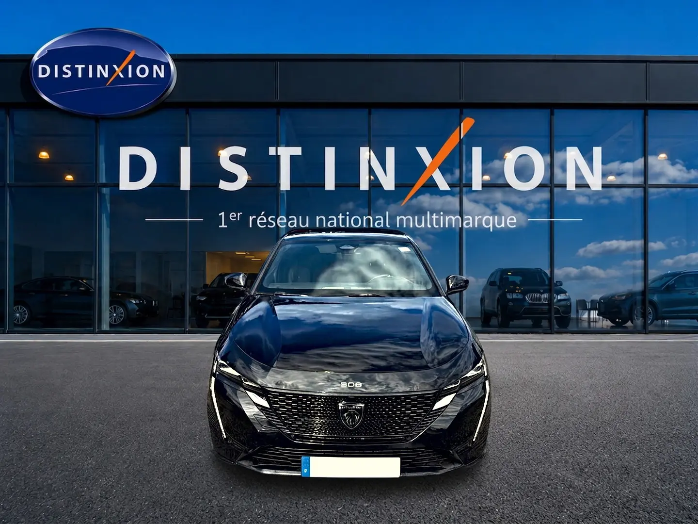 Vue frontale d'une Peugeot 308 noire 2025 garée devant une vitrine avec logo Distinxion en arrière-plan.