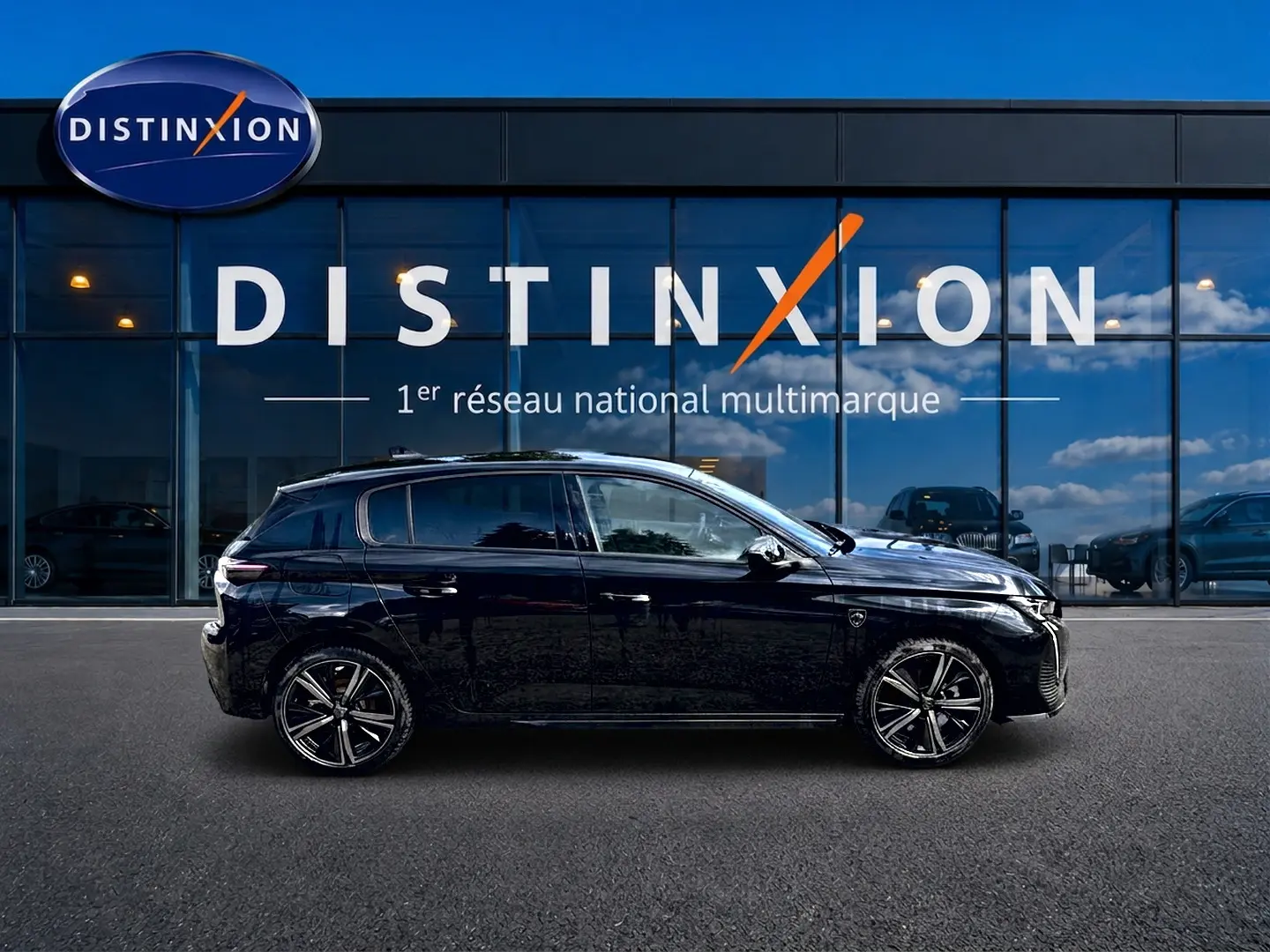 Profil côté gauche d'une Peugeot 308 noire 1.2 hybrid 145 GT e-DCS6 devant une vitrine Distinxion.