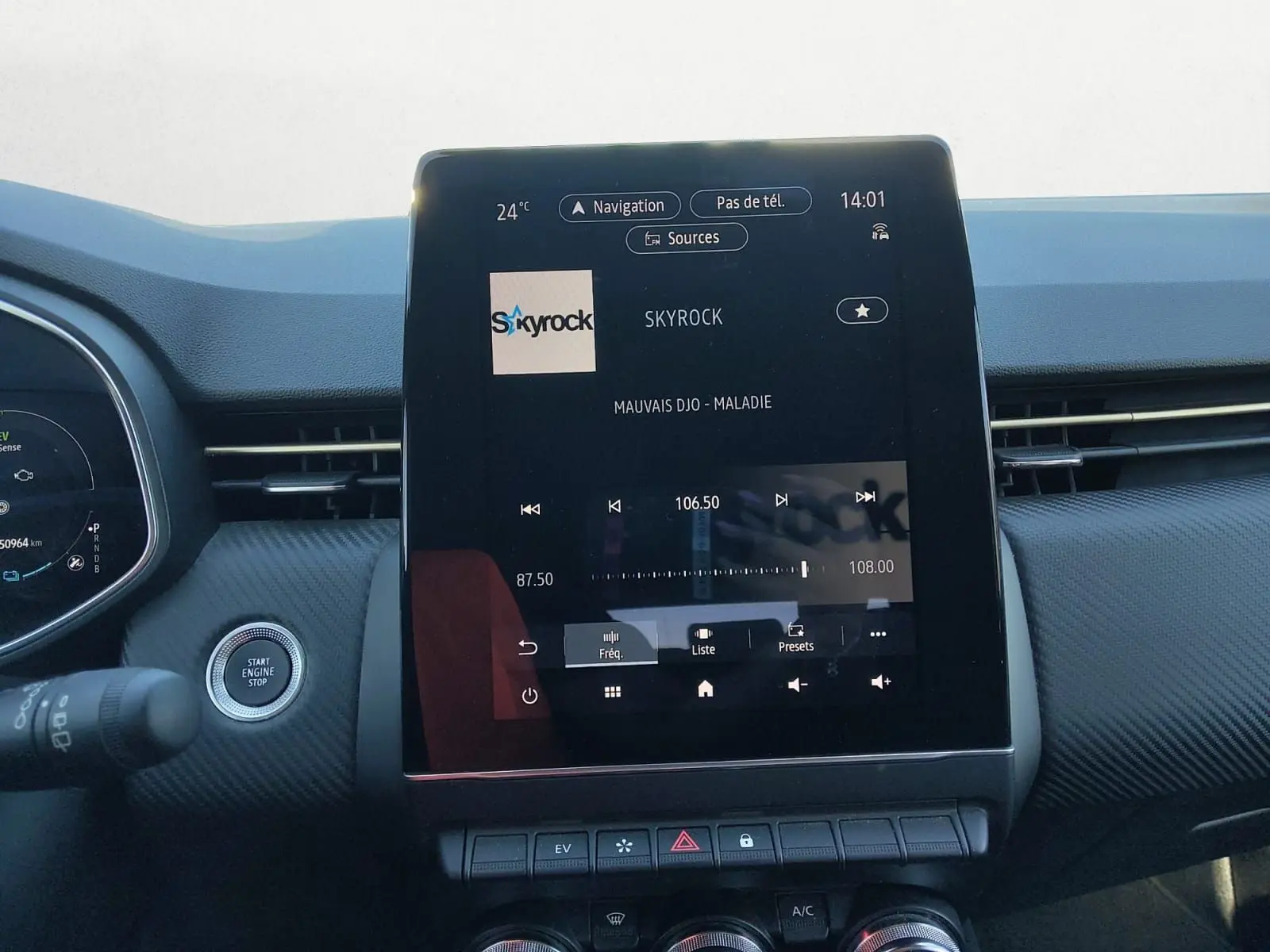 Vue intérieure centrée sur l’écran tactile du tableau de bord de la Renault Clio V gris foncé, affichant la radio Skyrock.