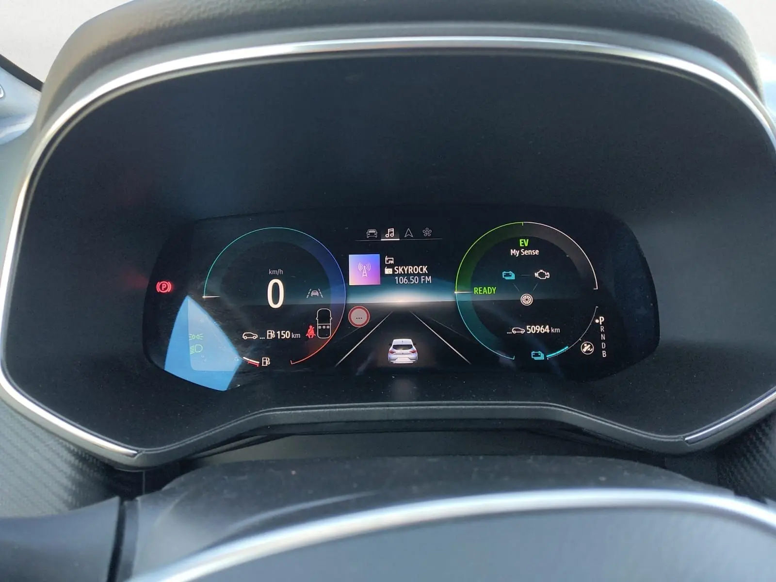 Vue rapprochée du tableau de bord numérique de la Renault Clio V E-Tech gris foncé, affichant la vitesse et l'autonomie.