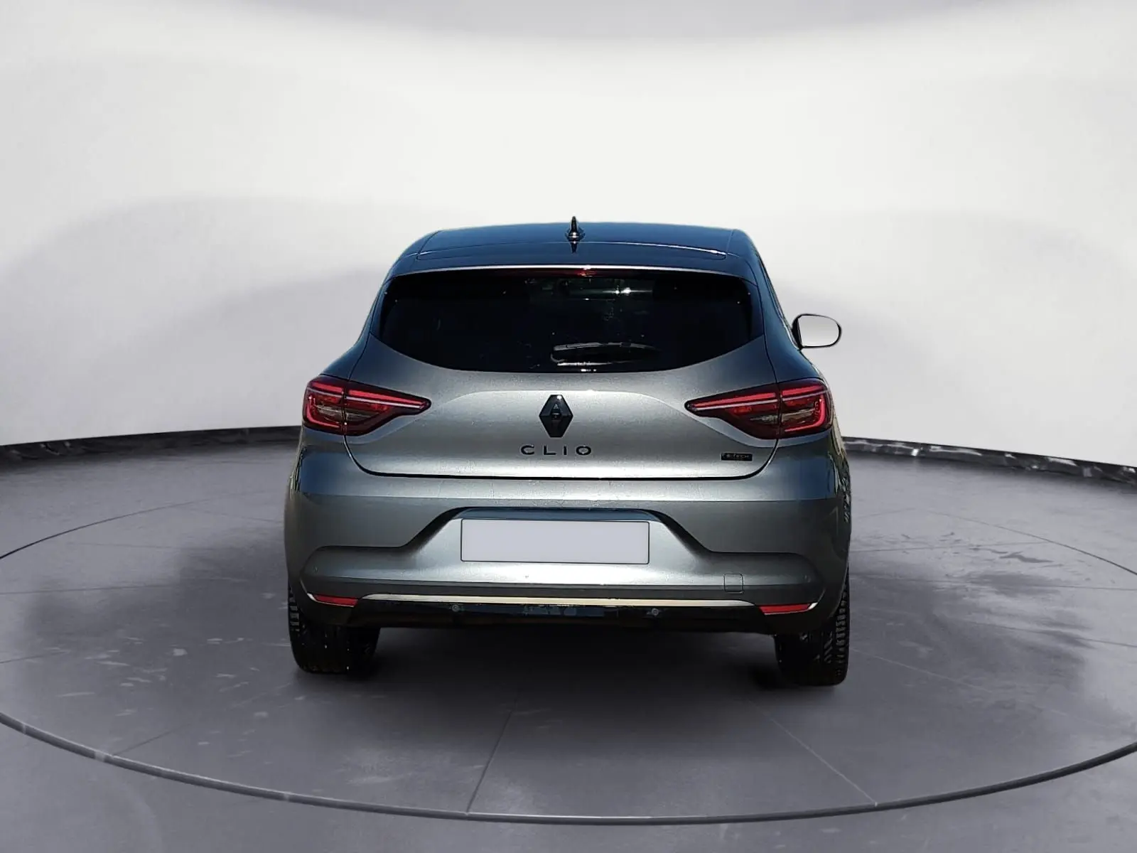 Vue arrière d'une Renault Clio V E-Tech Full Hybrid 145 gris foncé métal, avec feux arrière allongés et lunette arrière teintée.