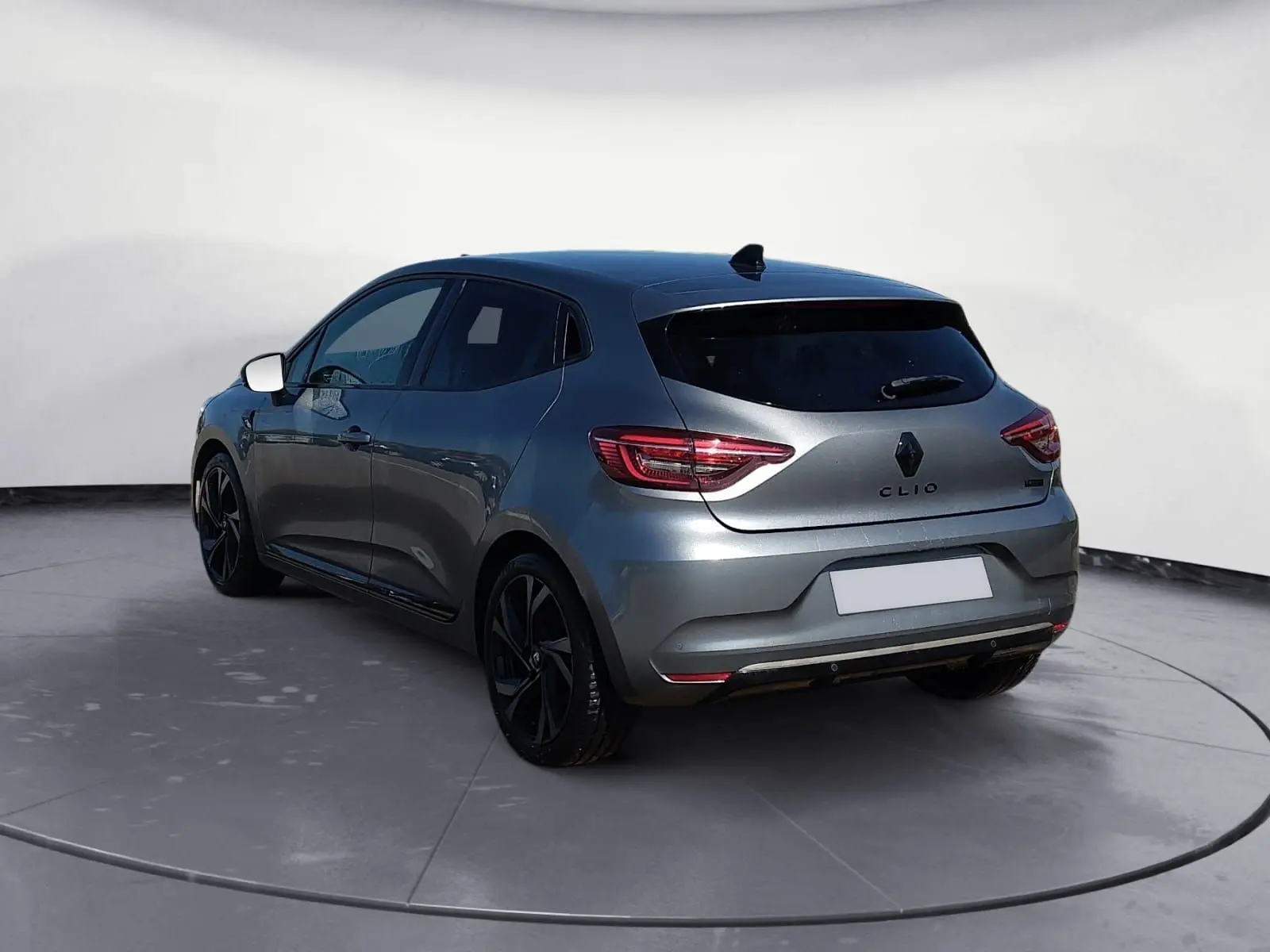 Renault Clio V E-Tech Full Hybrid gris foncé métal vue 3/4 arrière droit avec jantes noires et vitres teintées.