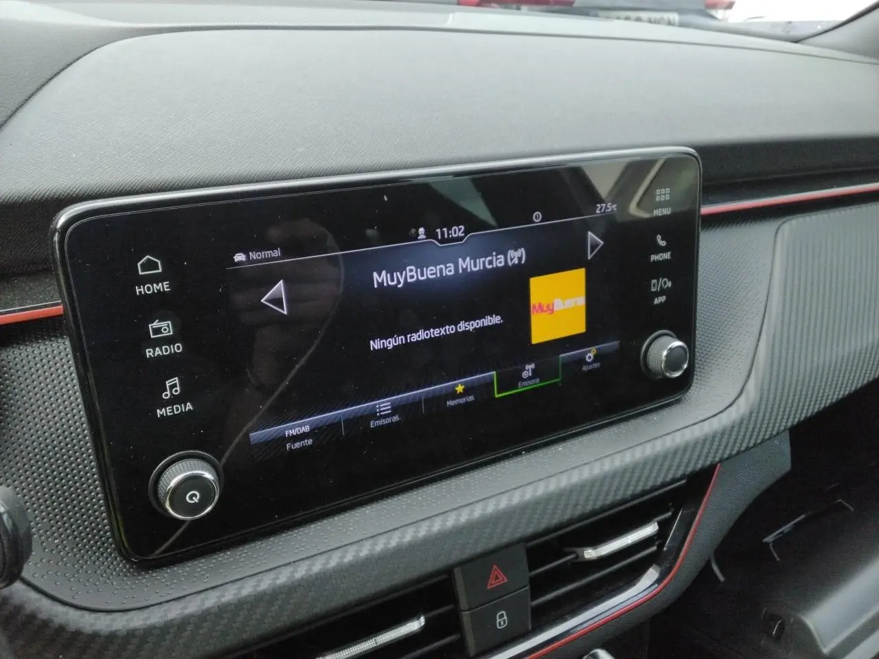 Gros plan sur l’écran central tactile du tableau de bord du Skoda Kamiq Monte-Carlo avec insert carbone et liseré rouge.
