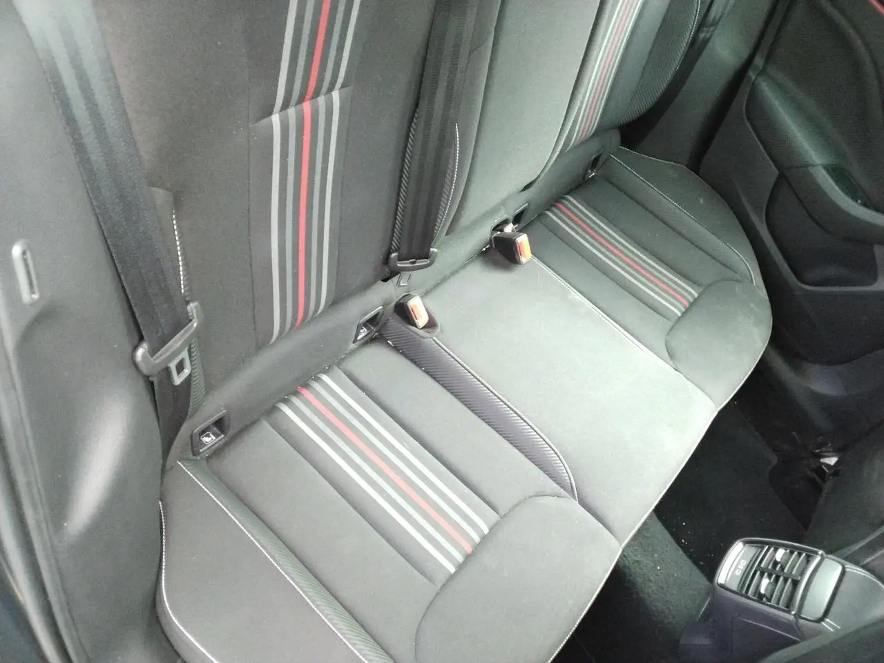 Vue plongeante sur la banquette arrière noire avec bandes grises et rouges du Skoda Kamiq Monte-Carlo 2025.