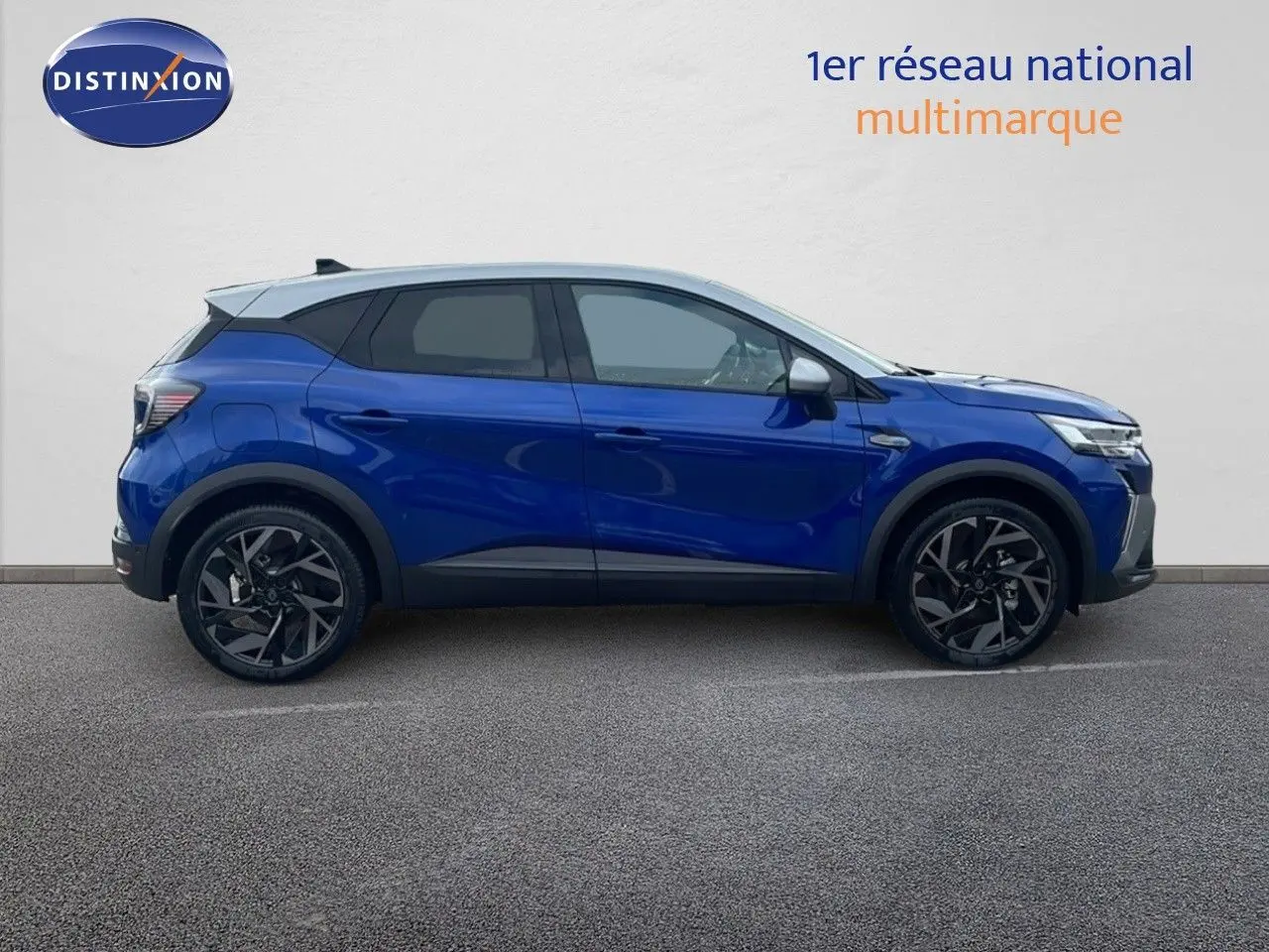Profil côté gauche du Renault Captur E-Tech hybride 2025 en bleu Iron Metal avec toit gris et jantes noires.