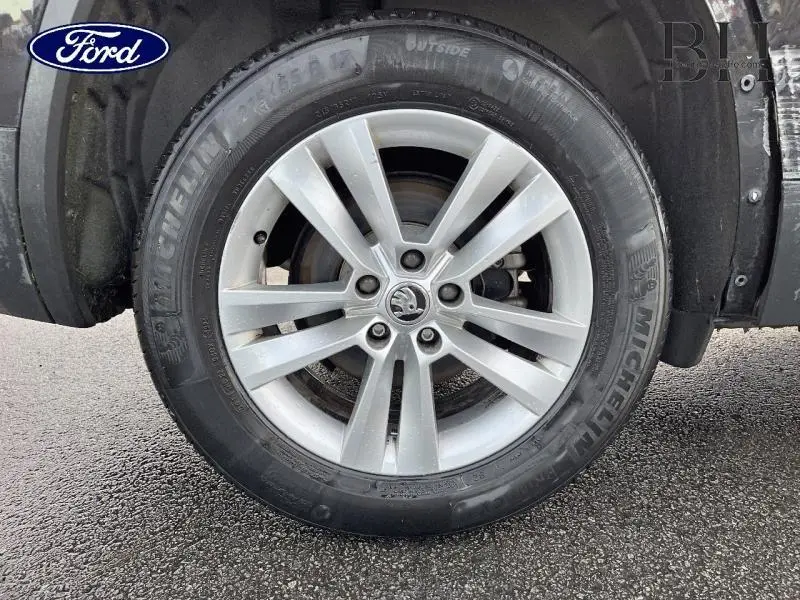 Gros plan sur la jante alu argentée et pneu Michelin d'un Skoda Kodiaq noir Magic Nacré côté gauche.