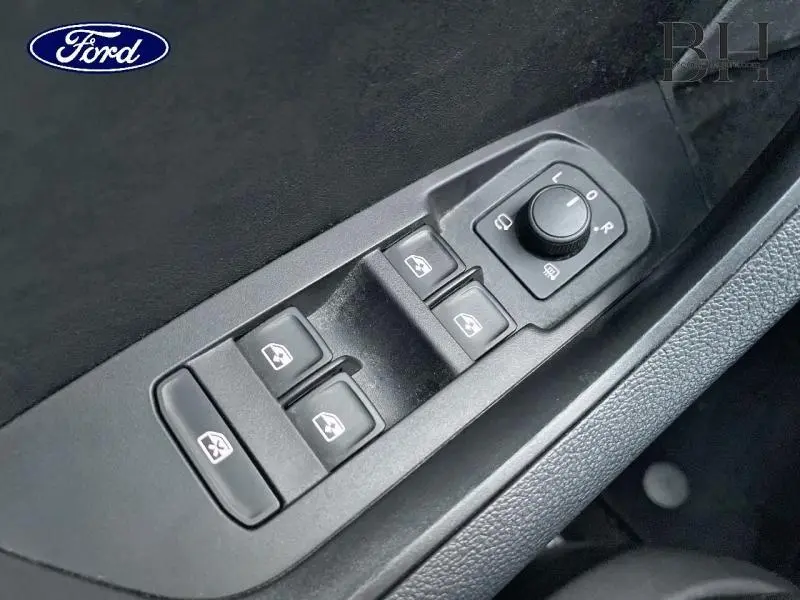 Gros plan sur les commandes électriques des vitres et des rétroviseurs côté conducteur d'un Skoda Kodiaq noir Magic Nacré.