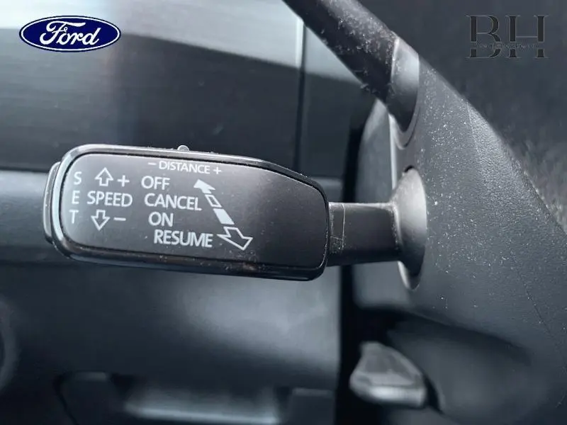 Gros plan sur la commande de régulateur de vitesse à gauche du volant d'un Skoda Kodiaq noir Magic Nacré 2021