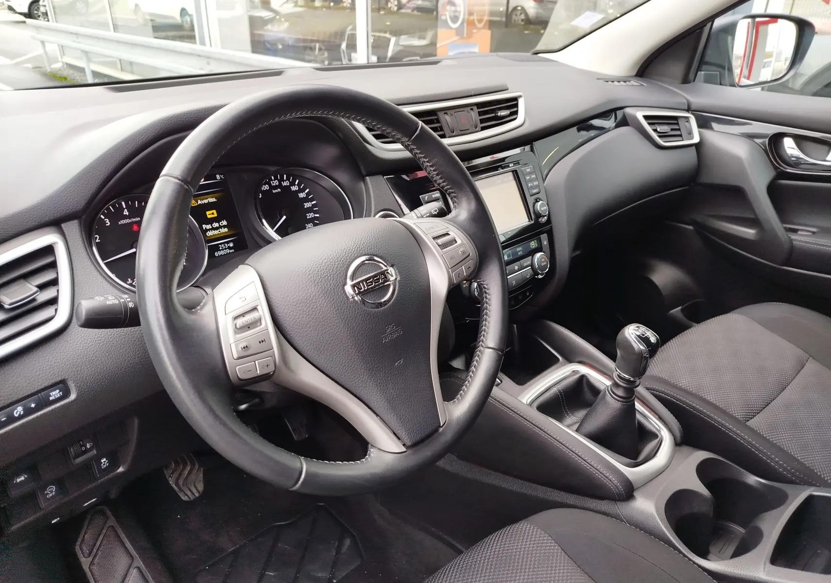 Vue de profil côté gauche d'un Nissan Qashqai 2017 bronze Ultime avec jantes alliage et vitres teintées.