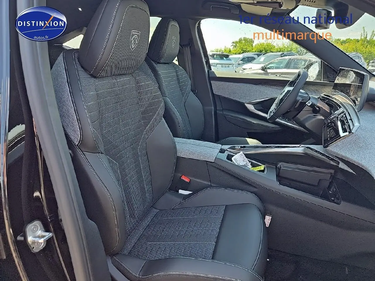 Vue intérieure côté conducteur du Peugeot 3008 noir 2025, sièges tissu et cuir avec logo Peugeot brodé sur appuie-tête.