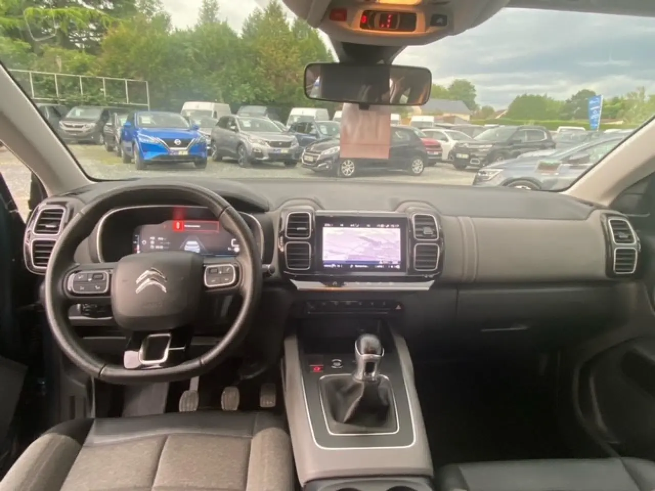 Vue intérieure du poste de conduite du Citroën C5 Aircross 2021 avec volant multifonction et écran tactile central.